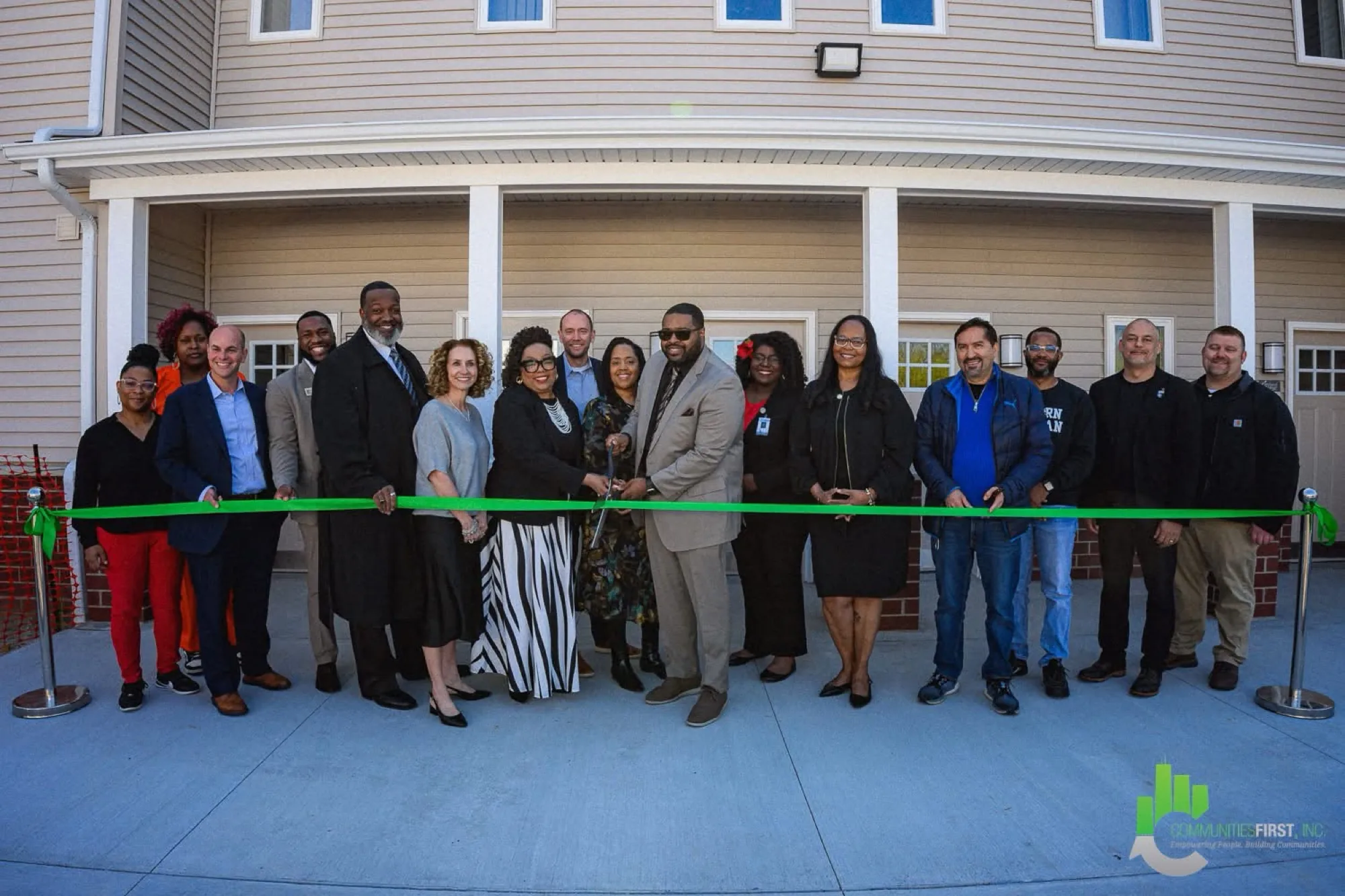Ribbon cutting, April 24, 2026: residents, partners and officials on the finished block.