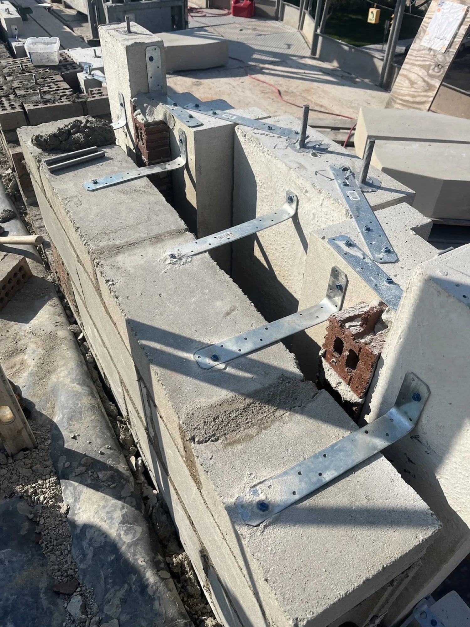Stainless steel strap anchors and threaded rod — the connection detail coordinated with the structural engineer.