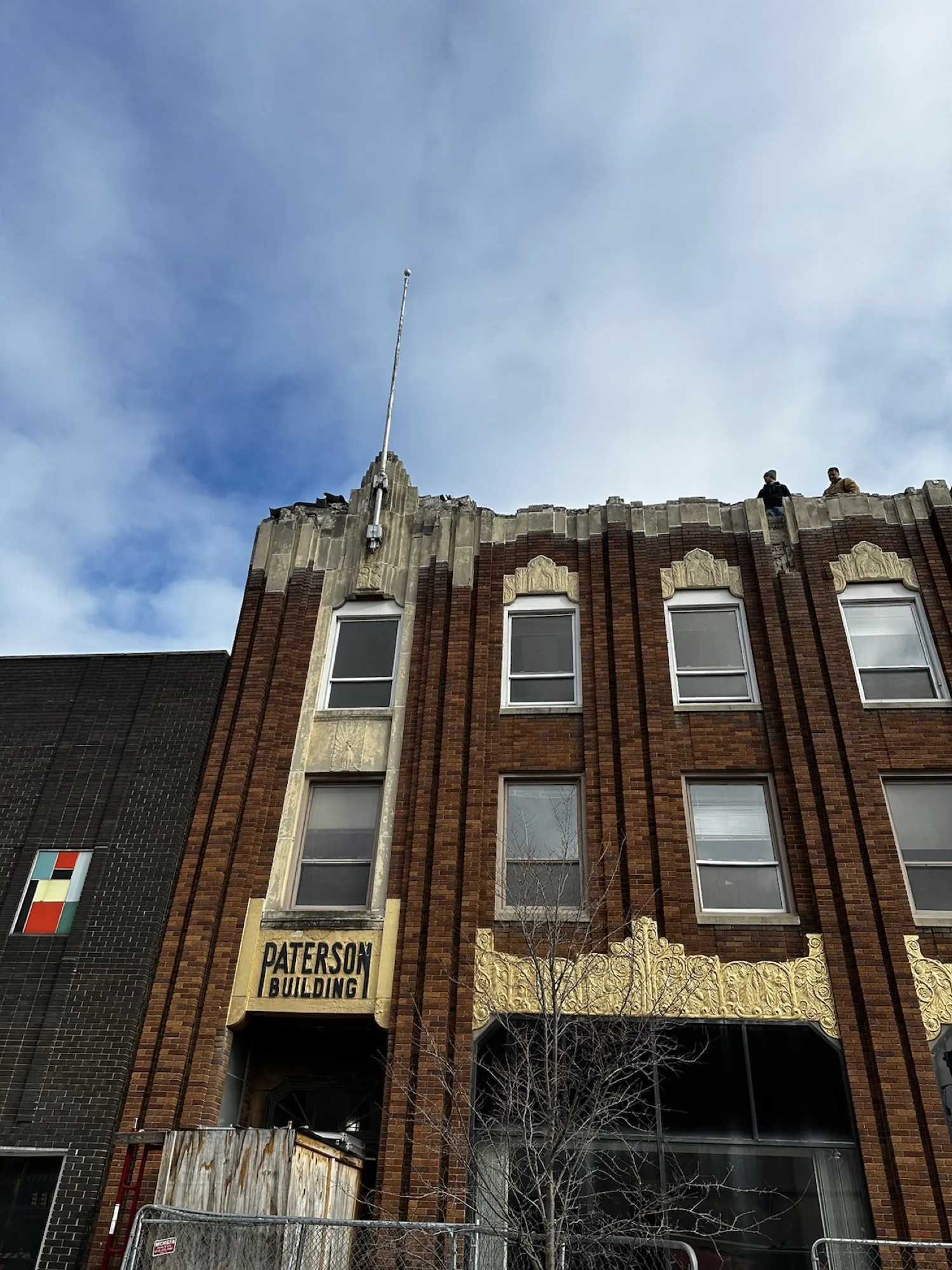 Before — the Saginaw Street entry, with the cornice already coming apart above the original signage.