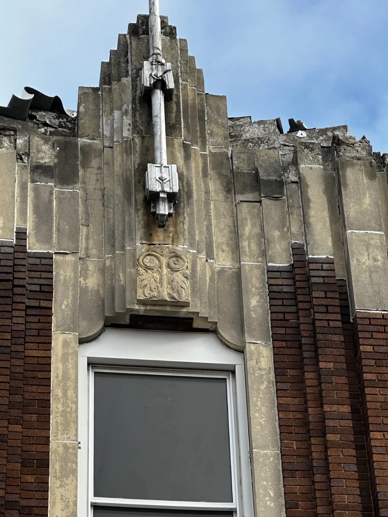 Before — open joints, spalled cast stone, and water tracking down behind the parapet.