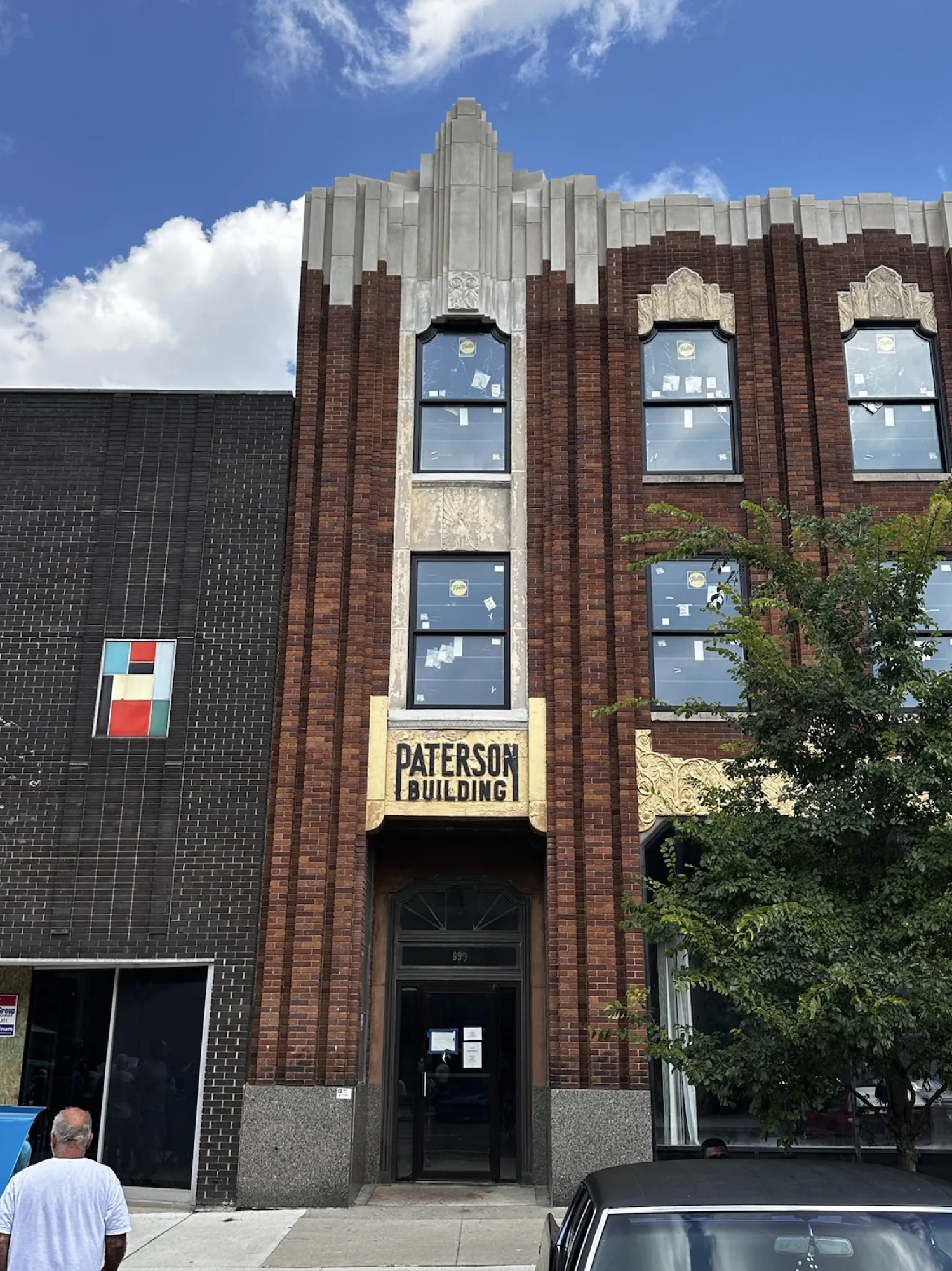 After — the Saginaw Street entry and restored corner parapet.